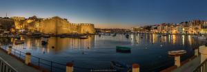 a river with boats in the water next to a castle at Le Margherite in Kalkara