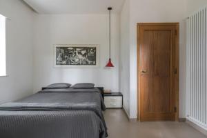 a bedroom with a bed and a wooden door at Terra Lavica Luxury Home Holidays in Nicolosi
