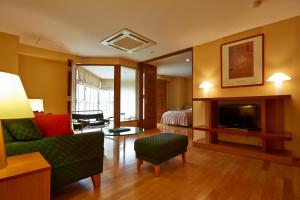 un soggiorno con divano, letto e TV di Fuji Premium Resort a Fujikawaguchiko