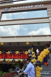 德拉敦的住宿－Paradise Inn，站在一座黄色气球的建筑前的人