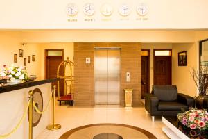een lobby met een wachtkamer met klokken aan de muur bij Lotos Inn & Suites, Nairobi in Nairobi