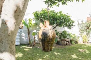 a large vase sitting in a yard next to a tree at Villa Amalia Suites Malaga in Málaga