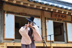 a man in a hat standing in front of a microphone at Jukheon Traditional House in Andong