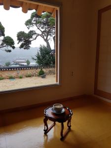 una mesa en una habitación con una ventana grande en Jukheon Traditional House en Andong