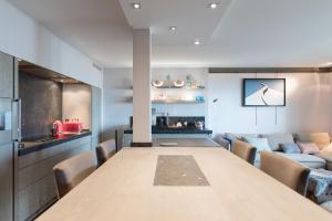 a dining room with a table and a couch at Le Grand Sillon - Le Georges in Saint Malo