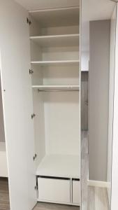 a walk in closet with white walls and shelves at Comfortable Studio only 20 minutes from International Conference Center Katowice best place for WUF2022 EEC TNF OFF etc in Siemianowice Śląskie
