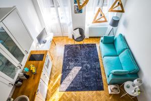 an overhead view of a living room with a blue couch at Ybl Apartment City Center in Székesfehérvár