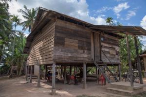 a small wooden house with a staircase in front at Chansor Community Homestay 2 in Phumĭ Réach Born (2)