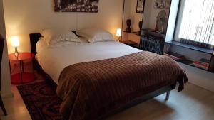 a large bed in a bedroom with two lamps at Notre Dame in Cannes