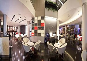 un restaurant avec des chaises et des tables blanches dans un bâtiment dans l'établissement Two Hotel Buenos Aires, à Buenos Aires