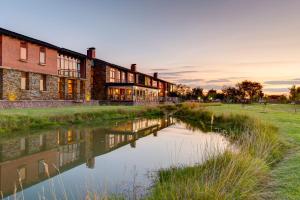 an old brick building next to a river at Riboville Boutique Hotel And Restaurant in Midrand