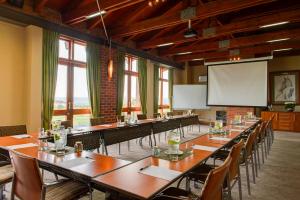 a large room with tables and chairs and a projection screen at Riboville Boutique Hotel And Restaurant in Midrand