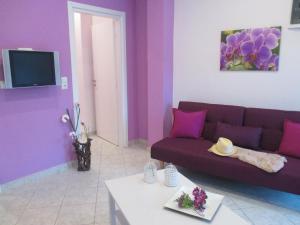 a living room with a purple couch and a table at Selene's House in Skala Kallirachis