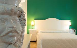 una camera da letto con una statua di una testa accanto a un letto di Hotel Villa Enrica - Aeolian Charme a Città di Lipari