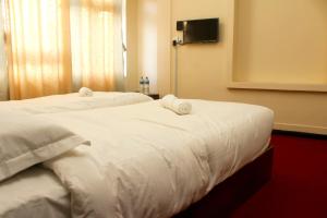 two beds in a hotel room with white sheets at Gorkha Chhen bed & breakfast in Gorkhā