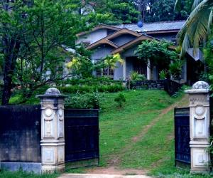 two gates in front of a house at Bee Line Cinnamon Estate Villa in Dickwella