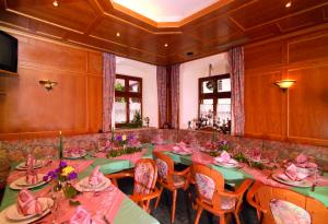 a dining room with tables and chairs with pink tablecloths at Landgasthof Schmidbaur in Donauwörth