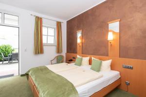 ein Schlafzimmer mit einem großen Bett in einem Zimmer in der Unterkunft Hotel Bitburger Hof in Bitburg