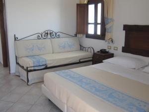 a hotel room with two beds and a window at Hotel Resort Nuraghe Arvu in Cala Gonone