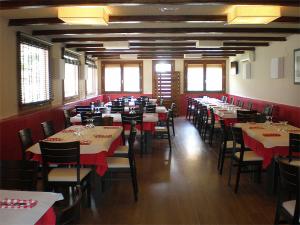 una sala da pranzo con tavoli e sedie con tovaglia rossa di Fonda Urquizu a Beceite