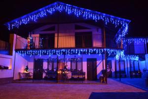 a house with christmas lights on the front of it at Guest House SunRise in Kamianets-Podilskyi