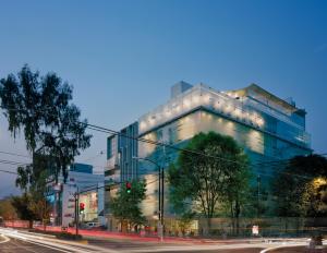 a large glass building on a city street at night at Habita, Mexico City, a Member of Design Hotels in Mexico City