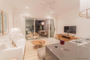 een woonkamer met een witte bank en een tafel bij O'Biches Beachfront Complex - Trou aux Biches in Trou aux Biches