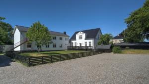 una gran casa blanca con una valla y un árbol en Villa Sofie Bed & Breakfast en Haslev