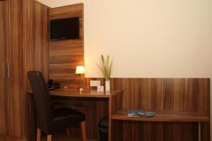 uma secretária com uma cadeira e um candeeiro num quarto em Villa Croatia & Restaurant Adria em Klingenberg am Main