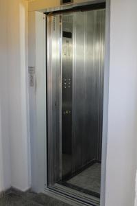 un ascensor en un edificio con una puerta de cristal en Pousada Recife Inn, en Recife