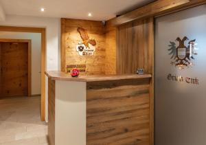 a bar in a restaurant with a wooden wall at Landgasthof Adler in Hinterhornbach