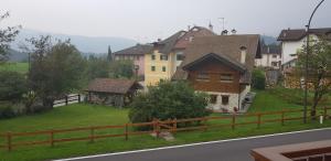 - une vue sur un village avec des maisons et une clôture dans l'établissement Casa vacanze in Trentino. Altopiano di Lavarone, à Lavarone