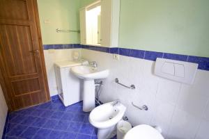 a bathroom with a sink and a toilet and a mirror at Appartamento Il Prado - Goelba in Portoferraio +16 photos