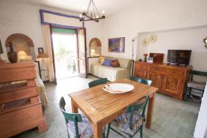 a living room with a wooden table and chairs at Appartamento Il Prado - Goelba in Portoferraio