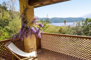 a balcony with a chair and a flower arrangement at Appartamento Il Prado - Goelba in Portoferraio