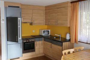 a kitchen with wooden cabinets and a sink and a microwave at Haus Amara in Saas-Grund