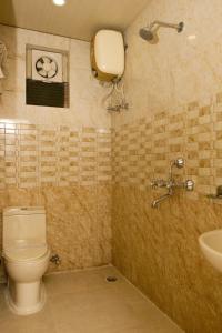 ein Bad mit einem WC und einem Waschbecken in der Unterkunft Hotel White House in Kalkutta