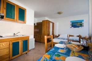 a kitchen with a table and a sink and a bed at Apartments Valentino in Vrsar