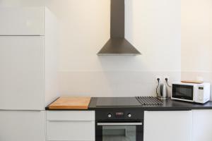 una cucina con piano di lavoro nero e forno a microonde di Lille Avenue a Lille