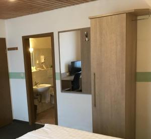 a room with a bathroom with a sink and a mirror at Gasthof Fröhlich in Langenbruck +6 photos