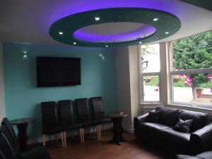 a living room with a couch and a purple ceiling at Heritage Hotel in Narborough