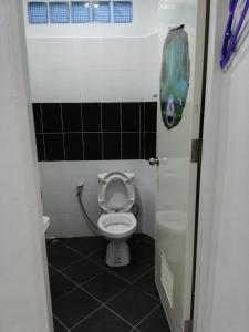 a small bathroom with a toilet in a stall at เซราะกราว โฮมสเตย์ in Sanom