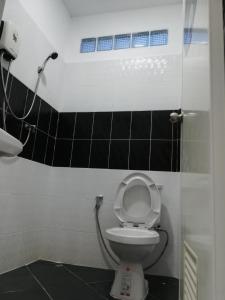 a bathroom with a white toilet with a shower at เซราะกราว โฮมสเตย์ in Sanom
