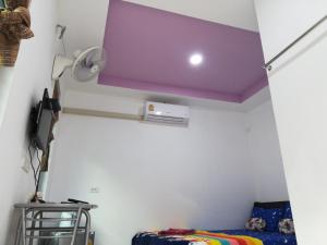 Sanomにあるเซราะกราว โฮมสเตย์の紫色の天井とベッドが備わるお部屋