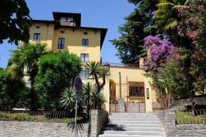 een geel huis met een trap ervoor bij Villa Maria Callas Sirmione in Sirmione