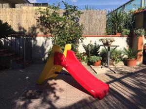 a red slide in a backyard with a table at Dea House Airport in Naples