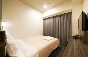 Postel nebo postele na pokoji v ubytování Sotetsu Fresa Inn Osaka Shinsaibashi