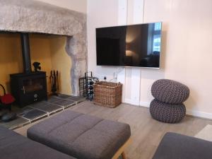 a living room with a fireplace and a flat screen tv at Ty Isa in Nefyn