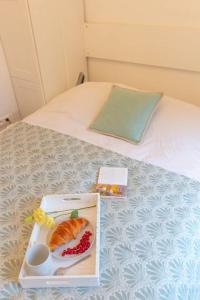 パリにあるArtiste du Montmartreのベッドの上に食品とフルーツの盛り合わせ
