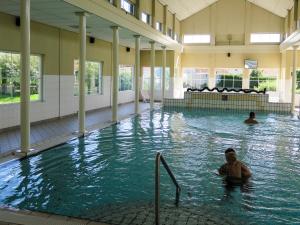 two people swimming in a large swimming pool at Aloha Beach House in Scharendijke